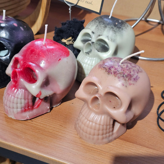 Skull-shaped candles on a wooden surface