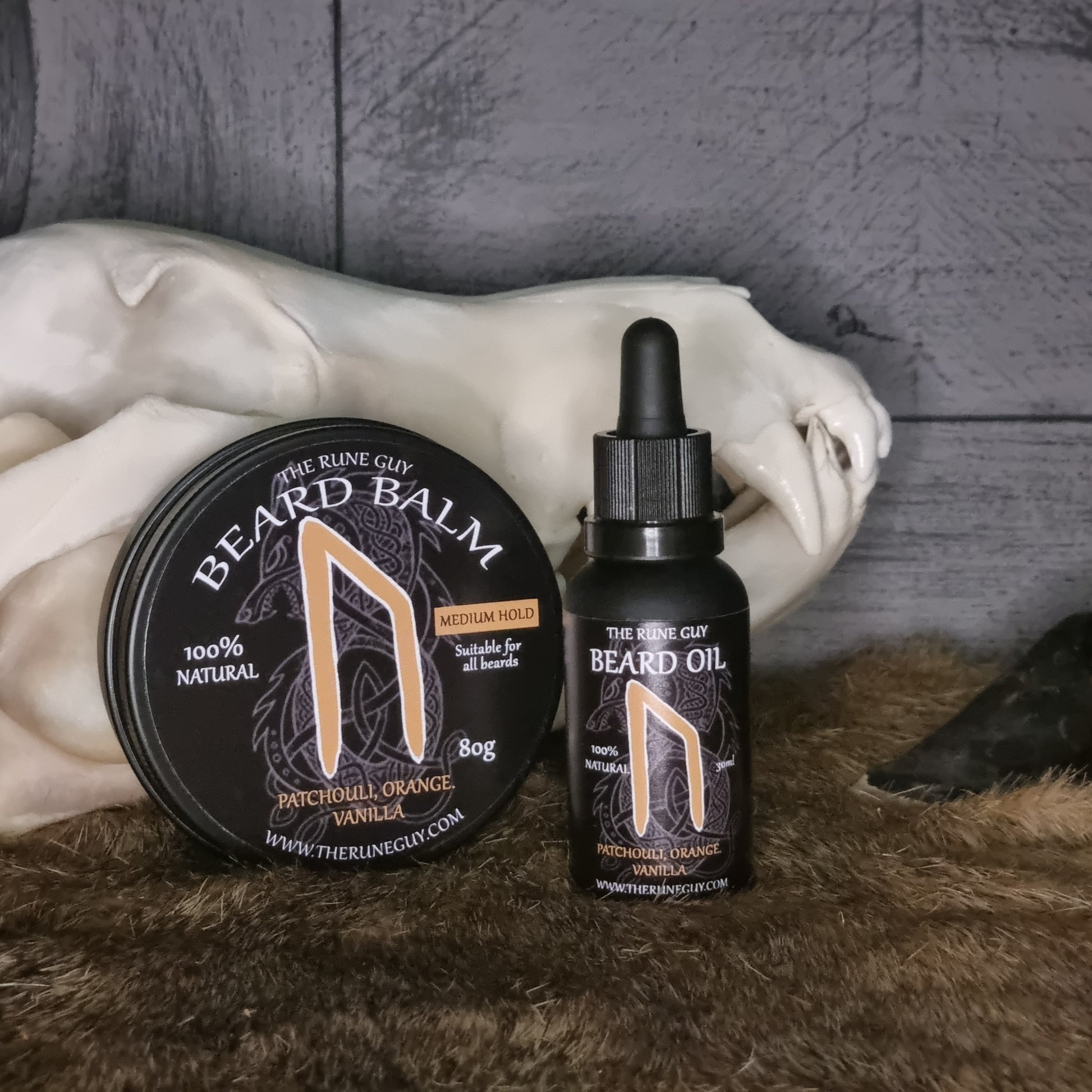 Beard care products including a balm and oil on a marble surface with a textured background.