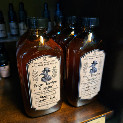 Two bottles of Four Thieves Vinegar on a wooden surface