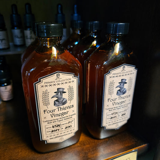 Two bottles of Four Thieves Vinegar on a wooden surface